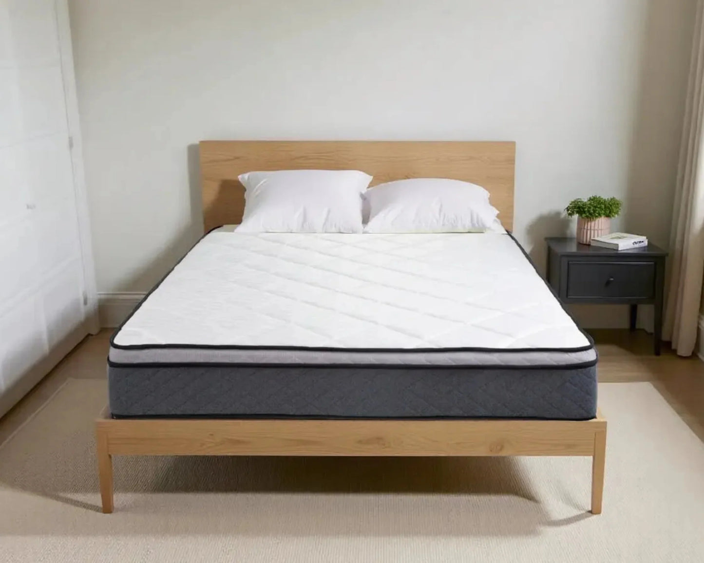 Mattress on wooden bed frame with pillows in a beige room.
