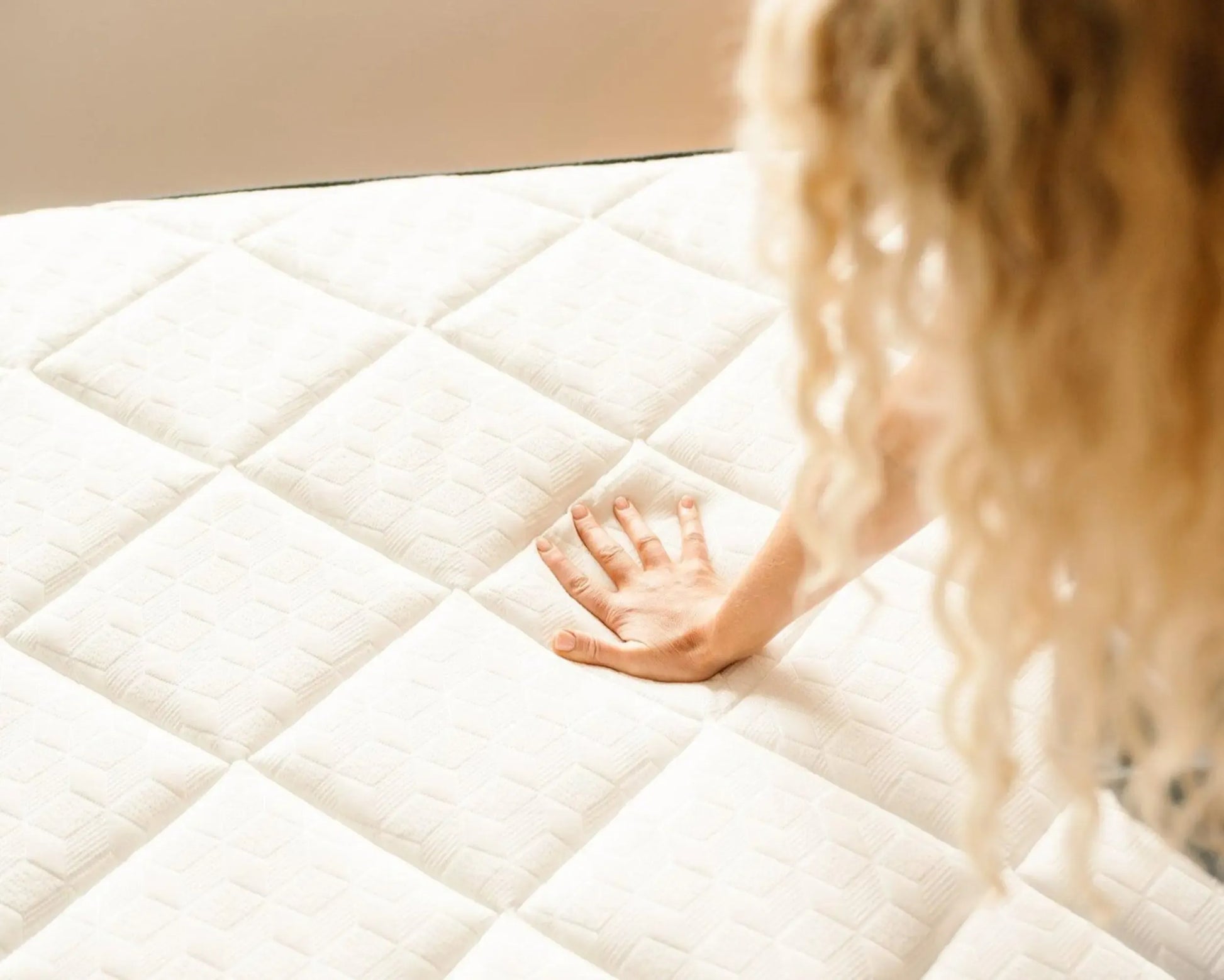 Child's hand reaching out to touch a mattress