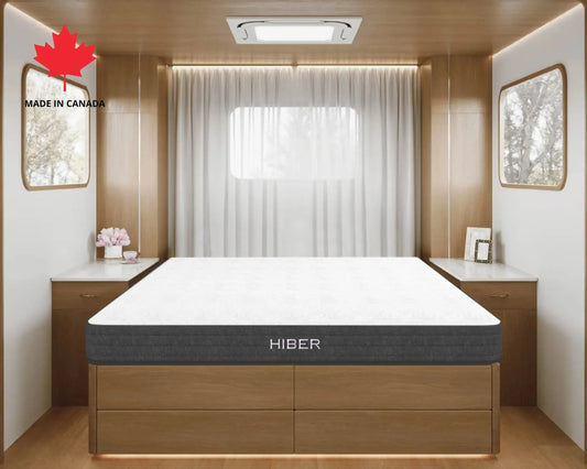 Hiber mattress in a modern bedroom setting with wooden furniture and a window.