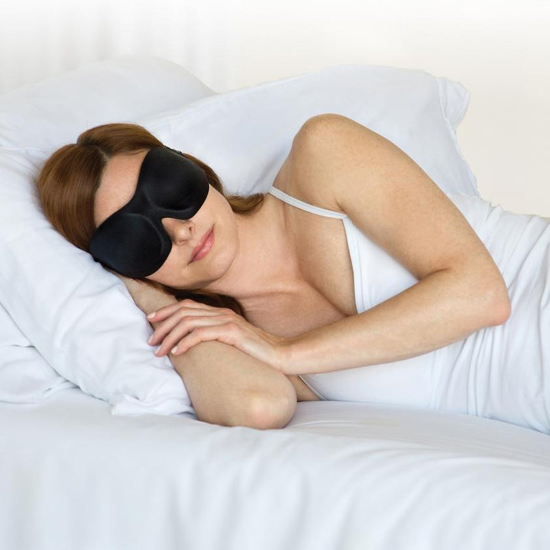 woman in white with a pair of Bedface blackout 40 blinks sleep mask sleeping on top of a memory foam pillow and Haven mattress with Starlight White sheet set