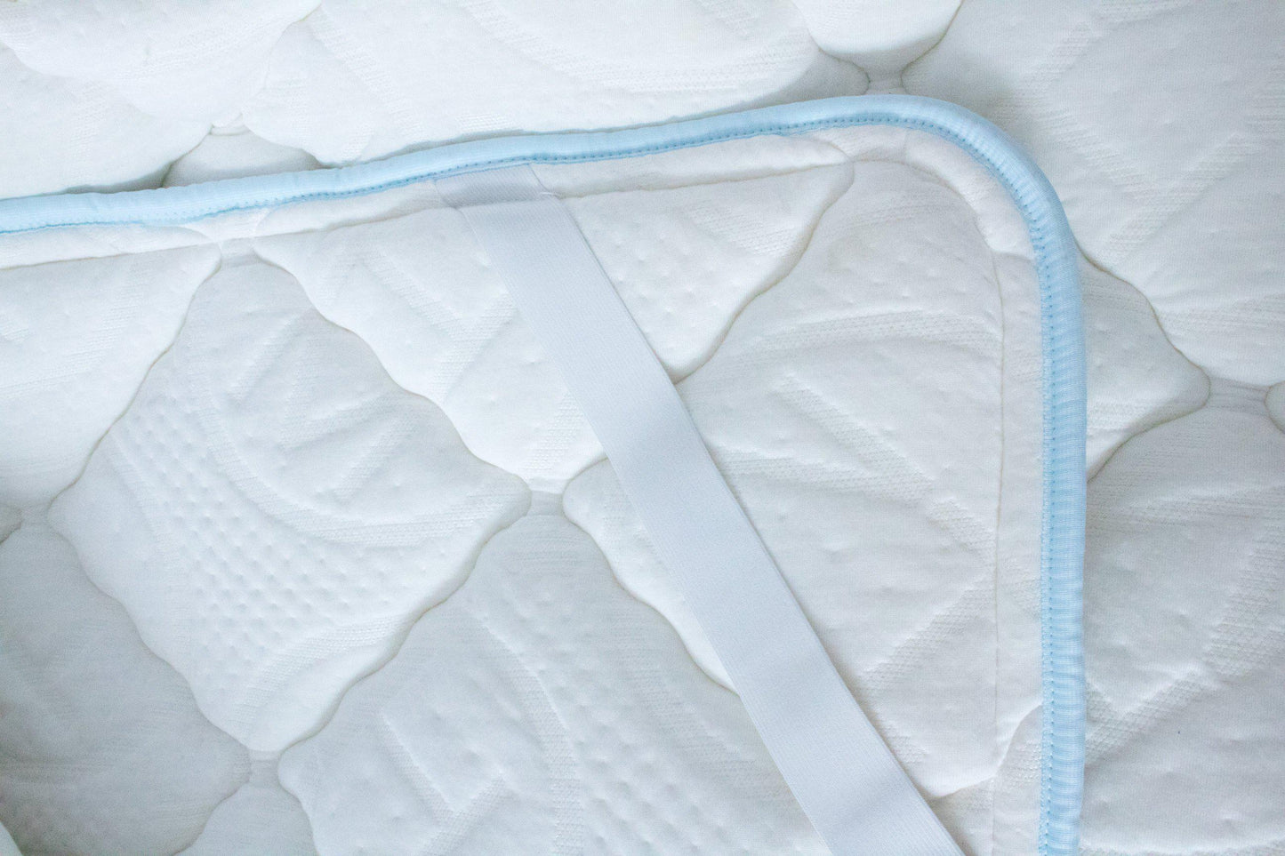 Close up Haven Soft Comfort topper with light blue edging and embossed Haven logo