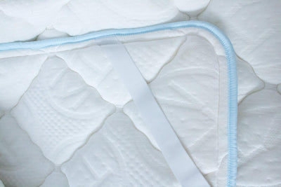 Close up Haven Soft Comfort topper with light blue edging and embossed Haven logo